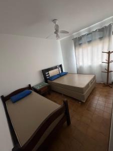 a room with two beds and a couch and a window at Pé na areia, Prainha in Arraial do Cabo