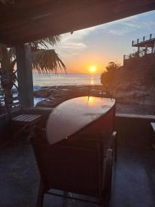 El GiganteにあるHostal Pelicanの海のそばのテーブルに置かれたサーフボード +2枚の写真