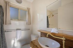 a bathroom with a toilet and a sink and a mirror at Reflections Burrinjuck Waters - Holiday Park in Bookham +96 photos