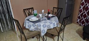 a table with a bottle of wine and glasses on it at Livi's Hide-Away! in Spanish Town +35 photos