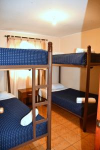 a room with three bunk beds and a table at Cabañas Rey Pacific in La Serena