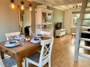 a kitchen and dining room with a wooden table and chairs at Bungalow in Sint Maartenszee near Beach in Sint Maartenszee
