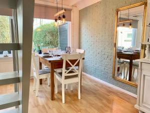 a dining room with a table and a mirror at Bungalow in Sint Maartenszee near Beach in Sint Maartenszee