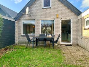 a table and chairs in front of a house at Bungalow in Sint Maartenszee near Beach in Sint Maartenszee