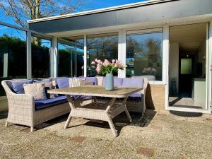 シント・マールテンスゼーにあるBungalow Sint Maartenszee near Sandy Beachの花瓶付きテーブルとソファ