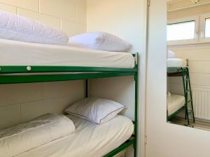 シント・マールテンスゼーにあるBungalow Sint Maartenszee near Sandy Beachの二段ベッド2組、鏡が備わる二段ベッド1組が備わる客室です。
