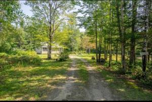 un camino de tierra en medio de un campo con árboles en Chalet Domaine du Lac, en  Notre-Dame de Montauban