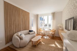 a living room with a couch and a table at Suite haut de gamme - Appartement vue sur mer - Boulogne Sur Mer - Nausicaa in Boulogne-sur-Mer