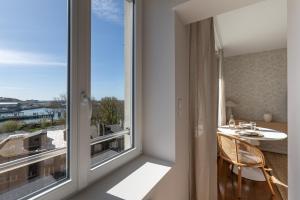 a room with a balcony with a table and a large window at Suite haut de gamme - Appartement vue sur mer - Boulogne Sur Mer - Nausicaa in Boulogne-sur-Mer