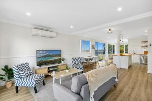 un salon avec un canapé et une table dans l'établissement Riverbank Cottage & Studio, à Shoalhaven Heads