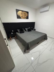 ein Schlafzimmer mit einem Bett und einem Gemälde an der Wand in der Unterkunft Torres del Mar in Manzanillo