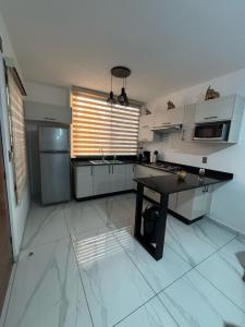 eine große Küche mit einem Tisch und einem Kühlschrank in der Unterkunft Torres del Mar in Manzanillo