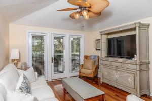a living room with a white couch and a tv at Sandpiper Court 14 by Wild Dunes, with Amenities in Isle of Palms +44 photos