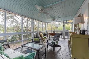 a screened in porch with chairs and a ceiling fan at Sandpiper Court 14 by Wild Dunes, with Amenities in Isle of Palms