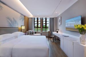 Postel nebo postele na pokoji v ubytování Sanya Han's Grace Hotel
