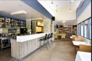 a bar in a restaurant with tables and chairs at Townhouse 7 - Located at FOOTPRINTS PRESTON BEACH RESORT in Preston Beach