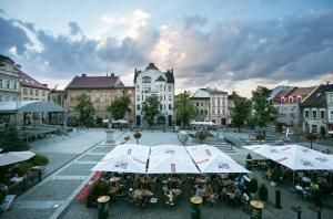 an empty square with tables and umbrellas in a city at Apartament na Starówce in Bielsko-Biała