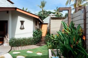 a backyard with a wooden walkway leading to a house at Belukar Villas in Gili Trawangan