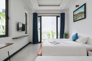 ホイアンにあるSunora Villa Hoi Anの大きなベッドと窓のある白い寝室