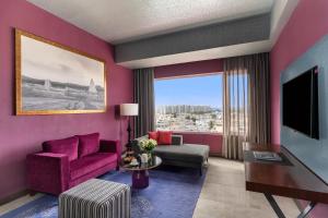 a living room with pink walls and a large window at Grand Mercure Bengaluru at Gopalan Mall - An Accor Brand in Bengaluru
