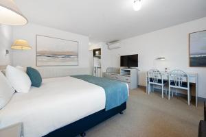 a bedroom with a bed and a desk and a television at Comfort Inn Devonport in Devonport