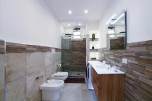 a bathroom with a toilet and two sinks and a shower at Orosei Mare A1 in Orosei