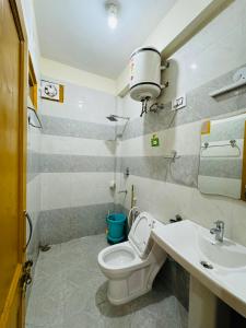 a bathroom with a toilet and a sink at Kullu Manali Homestay in Kulu