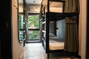 a hallway with bunk beds in a room with a window at Mad Monkey Manila in Manila +65 photos