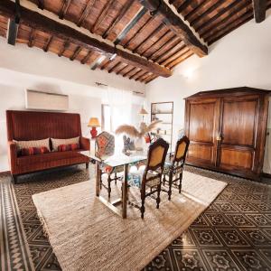 un soggiorno con tavolo, sedie e divano di A painting for each window with AIR CONDITIONING! a Siena