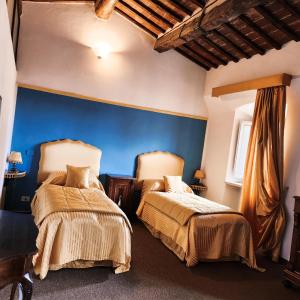 una camera da letto con due letti e una parete blu di A painting for each window with AIR CONDITIONING! a Siena