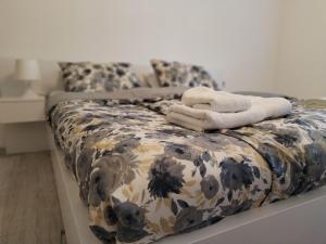 a bed with two white towels on top of it at Apartman Milica in Vršac