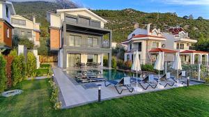 una casa con piscina con sedie e ombrelloni di GOLD Villa 6 a Oludeniz