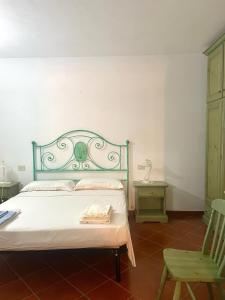 ein Schlafzimmer mit einem Bett und einem grünen Stuhl in der Unterkunft Casa Terrazza sul Golfo in Cannigione