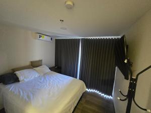 a bedroom with a bed and a window with lights at Apartment in Torre Artemisa in Tegucigalpa
