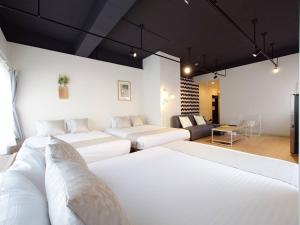pokój z dwoma łóżkami i kanapą w obiekcie Neighbor's Hotel 西広島駅前 w mieście Hiroszima