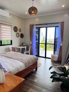 um quarto com uma cama e uma porta de vidro deslizante em Sondela Lambug Room2 w pool mountain seaview em Badian