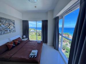 麦克坦La Mirada Residences Sea-view Suites的一间配有大床和大窗户的卧室