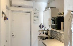 eine kleine Küche mit Spüle und Mikrowelle in der Unterkunft Lovely Apartment In Nexø With Sauna in Neksø