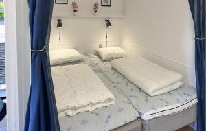 zwei Betten in einem Zimmer mit blauen Vorhängen in der Unterkunft Lovely Apartment In Nexø With Sauna in Neksø