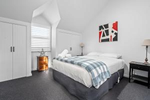 a bedroom with a bed with a plaid blanket at Moyne River View House in Port Fairy