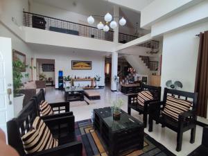 洛博克Antonio Homestay的客厅配有黑色椅子和桌子