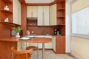 małą kuchnię z drewnianym stołem i krzesłami w obiekcie Jasny i Delikatny Apartament Sun Seasons 24 w Kołobrzegu by Noclegi Renters w Kołobrzegu