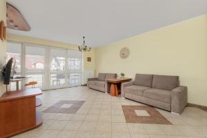 salon z dwiema kanapami i stołem w obiekcie Jasny i Delikatny Apartament Sun Seasons 24 w Kołobrzegu by Noclegi Renters w Kołobrzegu