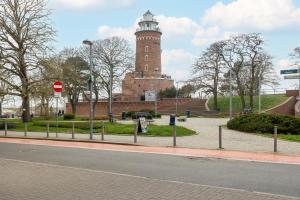 budynek z wieżą zegarową na środku ulicy w obiekcie Jasny i Delikatny Apartament Sun Seasons 24 w Kołobrzegu by Noclegi Renters w Kołobrzegu