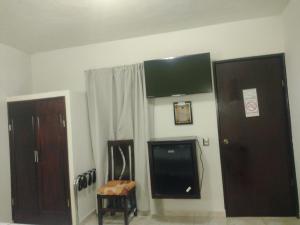 a room with two doors and a television on the wall at Hotel El Refugio in Bernal
