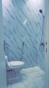 ein Badezimmer mit Toilette und blauer Marmorwand in der Unterkunft استديو هادئ النرجس in Quai
