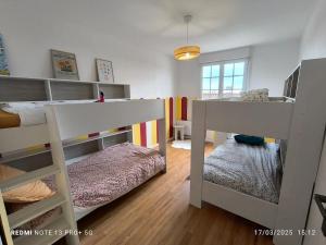 a bedroom with two bunk beds and a bed at Le Gîte du Cerisier in Pouzauges