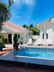 a swimming pool with a fountain in front of a house at Rooma Kichi Private Pool in Pantai Cenang