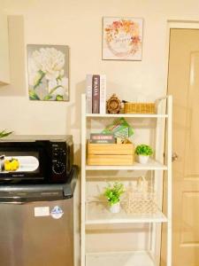 a kitchen with a shelf with plants and a microwave at CityHigh in Manila