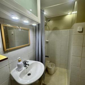 a bathroom with a sink and a shower with a mirror at CityHigh in Manila